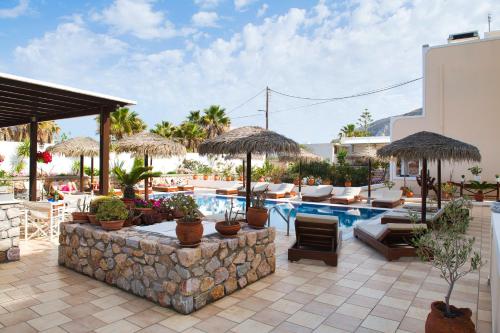 卡马利安吉拉别墅酒店的一个带椅子和遮阳伞的游泳池的度假酒店