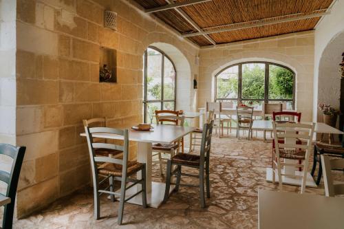 维拉诺瓦Masseria della Piana的用餐室设有桌椅和窗户。