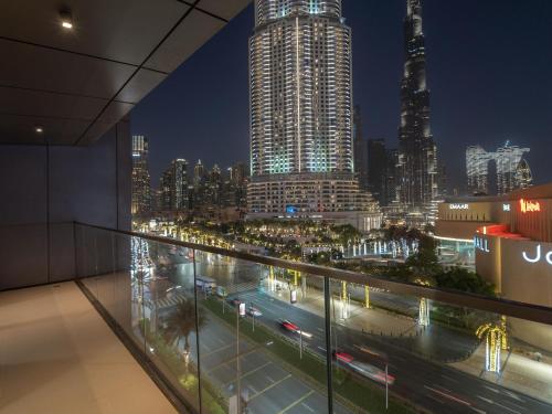 迪拜Luxurious Stylish Apartments Across Dubai Mall Burj Khalifa City Views的建筑在晚上可欣赏到城市美景