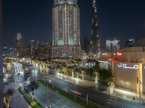 迪拜Luxurious Stylish Apartments Across Dubai Mall Burj Khalifa City Views的城市天际线,夜晚有繁忙的街道