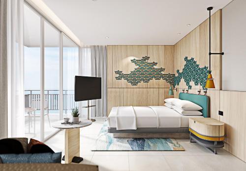 芭堤雅市中心芭堤雅假日酒店的一间卧室配有一张床、一张桌子和一台电视。