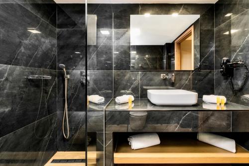 扎金索斯镇帕拉提诺酒店的带淋浴、盥洗盆和镜子的浴室