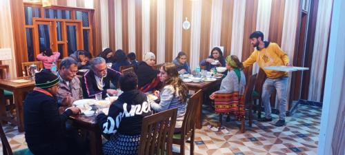 KanzalwanD’SHIEKHS RESORT GUREZ的一群坐在餐厅桌子上的人