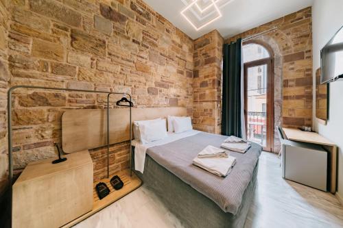希俄斯Chios City Inn的一间设有床铺和砖墙的房间
