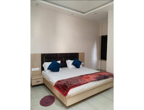 Sītāpur MūāfiThe Ramagya Hotel, Chitrakoot的一间卧室配有一张带蓝色枕头的大床