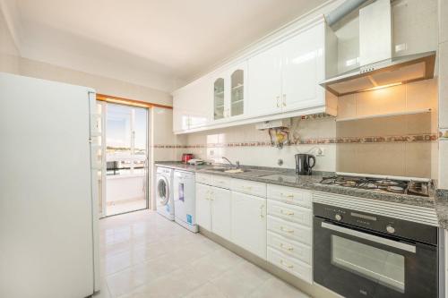 沙尔内卡GuestReady - Caparica Beach Lover's Dream的厨房配有白色橱柜、洗衣机和烘干机