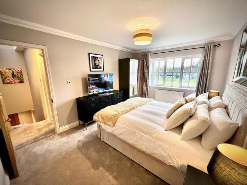 剑桥Honey Hill Cottage - 4 Bedroom Detached House的卧室配有一张大白色床和窗户