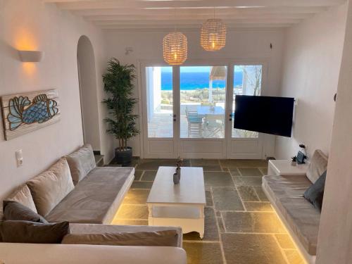 卡拉法蒂斯Thalia Myconian Suites的带沙发和电视的客厅
