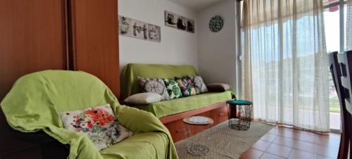 萨洛Reus y MAr Salou的客厅设有绿色沙发和窗户。