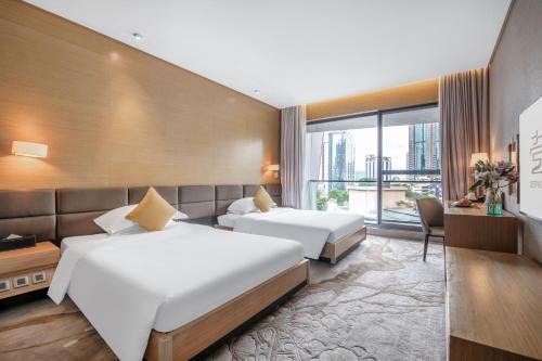 深圳深圳半山壹棠服务公寓的酒店客房设有两张床和窗户。