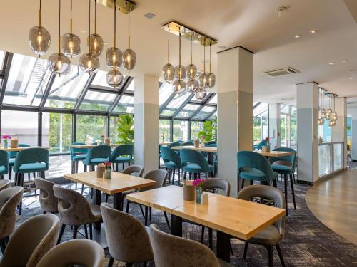 科隆科隆西美居酒店的餐厅设有桌椅和窗户。