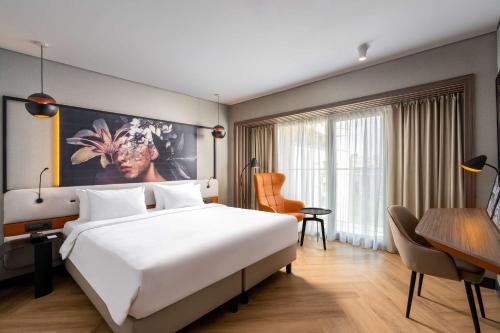 布加勒斯特布加勒斯特丽笙酒店的酒店客房设有一张大床和一张书桌。