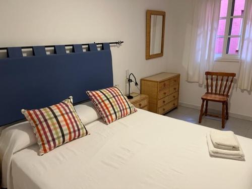 圣地亚哥海滩贝拉维斯塔戈梅拉公寓的一间卧室配有带2个枕头和椅子的床