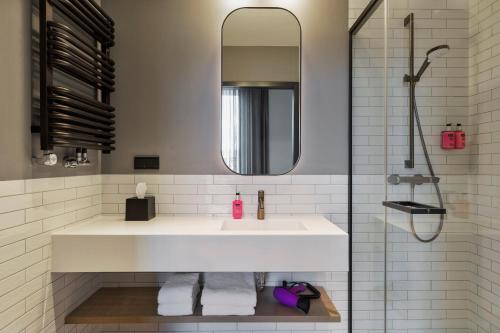 华沙Moxy Warsaw Praga的浴室配有白色水槽和淋浴。