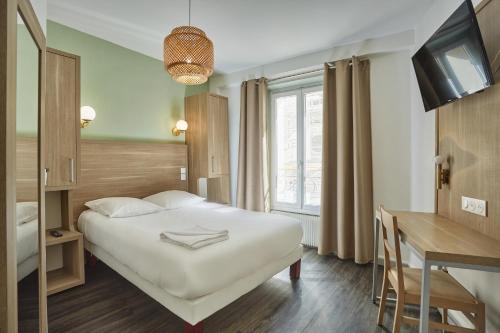巴黎巴黎北站梅尔里勒酒店的配有一张床和一张书桌的酒店客房