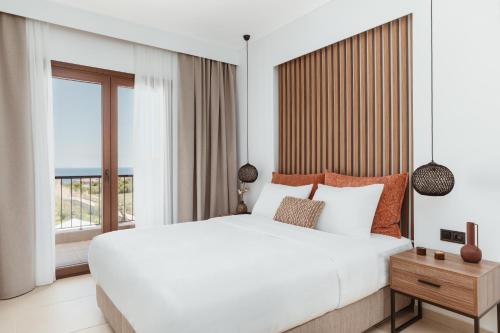 阿菲托斯Verano Afytos Hotel的卧室设有一张白色大床和一扇窗户。