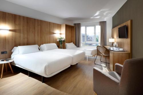 托尔托萨托尔托萨科罗娜SB酒店的酒店客房设有一张白色大床和椅子