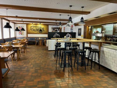 蒂蒂湖-新城Brauereigasthof Bären的一间带桌椅的餐厅和一间酒吧