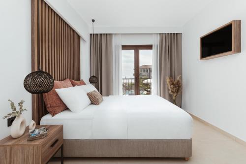 阿菲托斯Verano Afytos Hotel的卧室设有一张白色大床和一扇窗户。