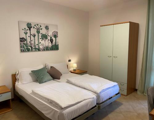 提尼亚类Ca' ai Tigli的卧室配有白色的床和橱柜。