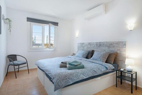 普拉亚布兰卡Mi Casita的白色卧室配有一张大床和椅子