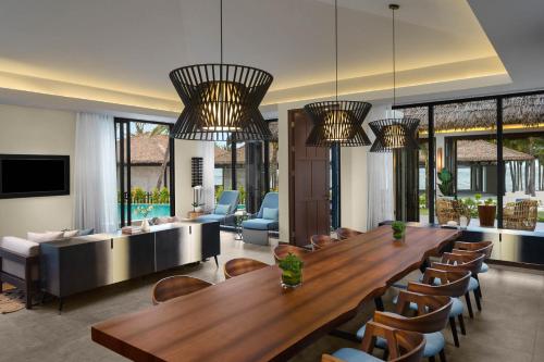 富国New World Phu Quoc Resort的客厅配有大型木桌和椅子