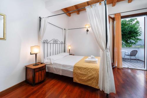 马内尔巴洛坎达达维托里奥酒店的一间卧室设有天蓬床和窗户。