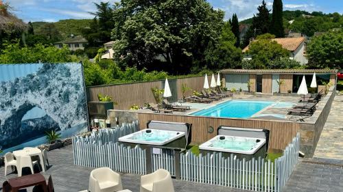 圣马丁阿尔代什Logis Hôtel Restaurant Bellevue的一个带两把椅子和围栏的游泳池