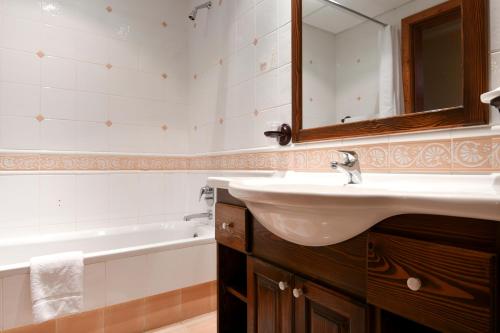 沙拉聚宝盆酒店的浴室配有盥洗盆、镜子和浴缸