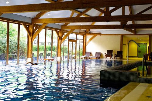 卢顿卢顿胡酒店、高尔夫球场&SPA的一座带木梁的建筑中的游泳池