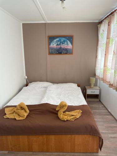 TahitótfaluPanoráma Nyaraló的一间卧室配有一张带两张黄色毛巾的床