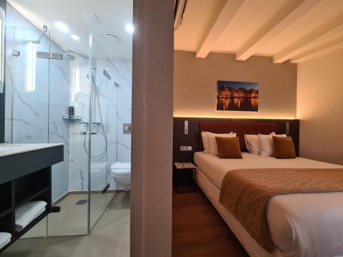 阿姆斯特丹大道酒店的一间卧室配有一张床,浴室设有淋浴。