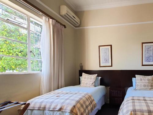 惠灵顿卡明斯宾馆的一间卧室设有两张床和窗户。