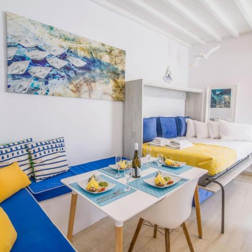米克诺斯城Like a white seagull in Mykonos!的一间房间,配有一张床和一张桌子,上面有食物