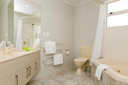 陶波Anchorage Resort Taupo NZ的带浴缸、卫生间和盥洗盆的浴室