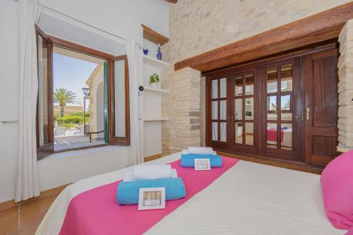 阿尔库迪亚Villa Can Cosme的一间卧室设有一张床和一个大窗户