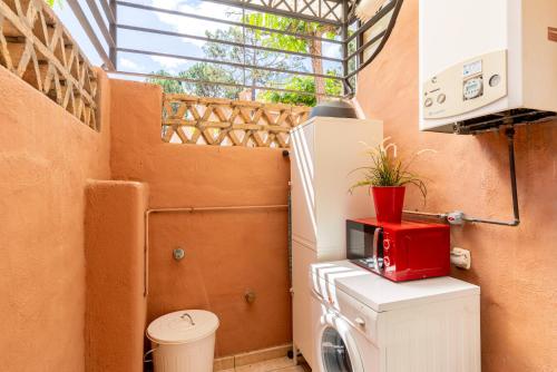 伊斯兰蒂拉ALTAVISTA ISLANTILLA GOLF by MSHOLIDAYS的一间小浴室,在洗衣机的顶部配有红色微波炉