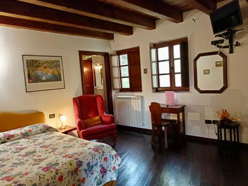 Vezzi PortioLe Petit Chateau的一间卧室配有一张床、一把椅子和一张书桌