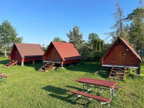 戈尼翁兹SZAŁASY drewniane nad rzeką BIEBRZA的三个谷仓的一组,在田野上设有野餐桌