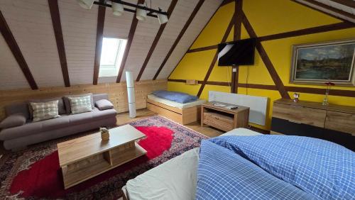 DegersheimGasthaus Fuchsacker的一间卧室配有一张床、一张沙发和一张桌子