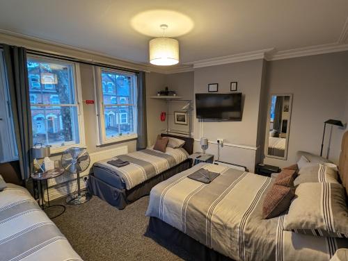 雷丁Caversham Lodge的酒店客房设有三张床和电视。