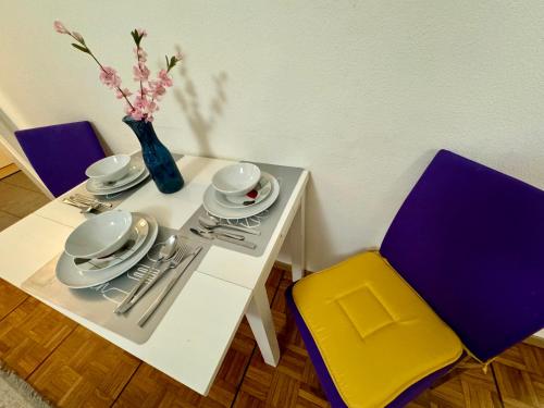 洛桑Apartahotel Confort的白色的桌椅和花瓶