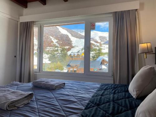 圣卡洛斯-德巴里洛切Catedral Sur departamento en Bariloche的一间卧室设有一张床和一个大窗户
