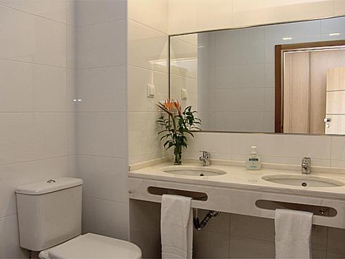 阿尔布费拉Apartamentos Turisticos Monte da Vinha II的浴室设有卫生间、2个盥洗盆和镜子