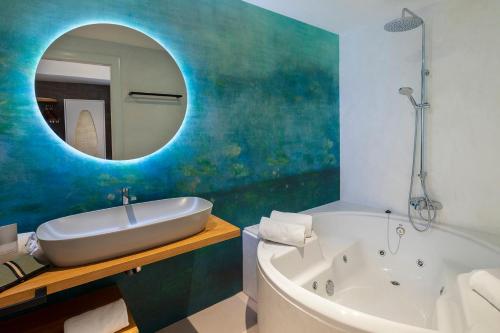 德拉塞尔瓦港克里斯托港酒店暨Spa的带浴缸、水槽和镜子的浴室