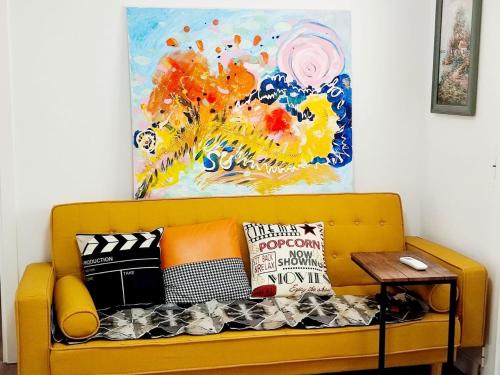 孔苏埃格拉SG ROOMS的黄色沙发、枕头和墙上的画作