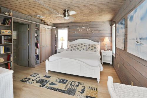 印第安帕斯Coastawhile by Pristine Properties Vacation Rentals的卧室设有白色的床和木墙