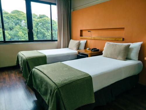 门多萨拉宜斯艾克卡吉酒店的带窗户的酒店客房内的两张床