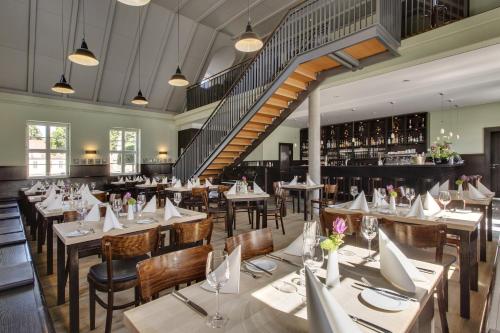 新哈登贝格新哈登贝格施洛斯酒店的一间带桌椅的餐厅,以及楼梯