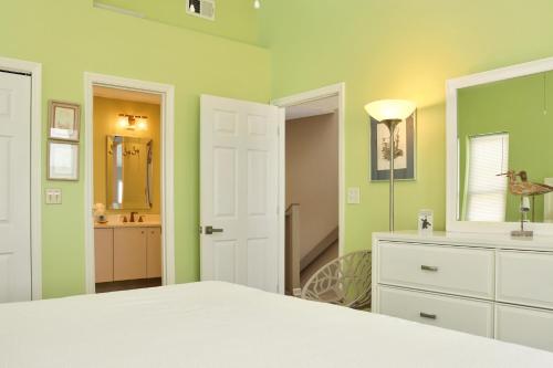 印第安帕斯Indian Summer by Pristine Properties Vacation Rentals的一间带绿色墙壁和一张床的卧室以及一间浴室。